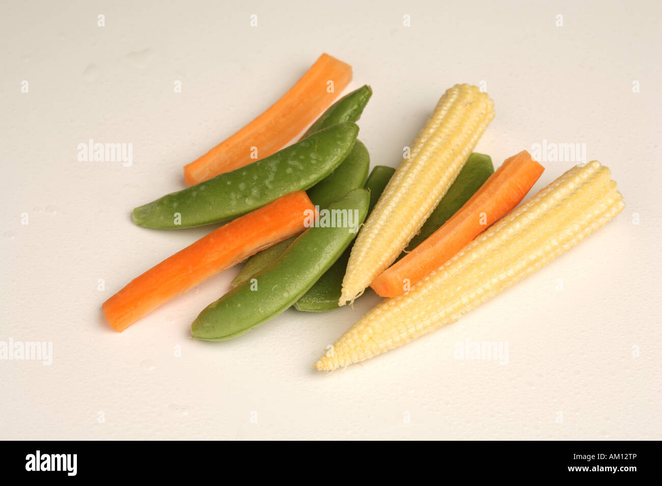 A cutout shot of carrots mangetout and baby sweetcorn against a white background Stock Photo