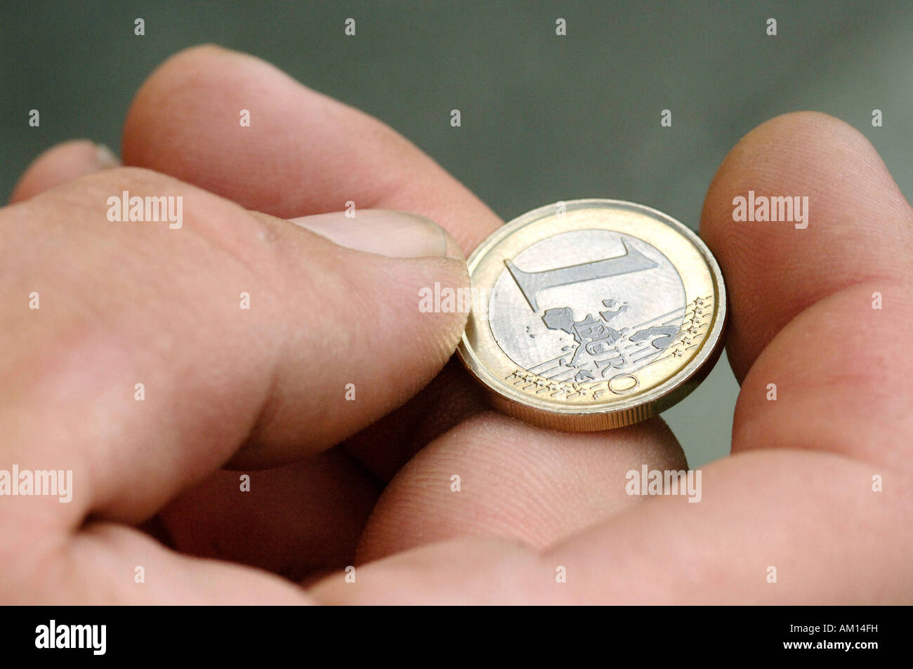Hand with one Euro coin Stock Photo