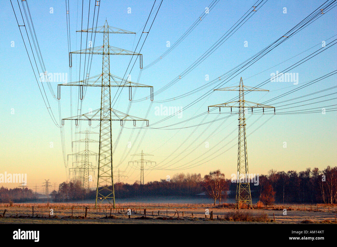 Power poles high voltage electrical power lines sunrise at winter