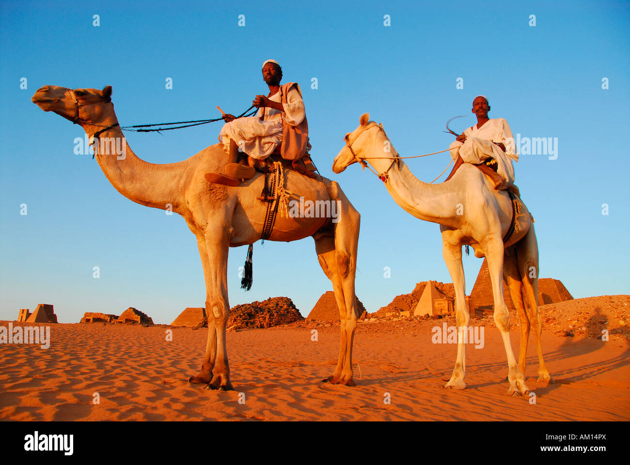 Nomads on camels in front of the pyramids of Meroe, Meroe, Sudan Stock Photo