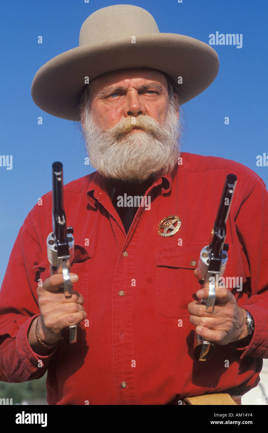 Old West gunslinger drawing guns during historical reenactment CA Stock Photo