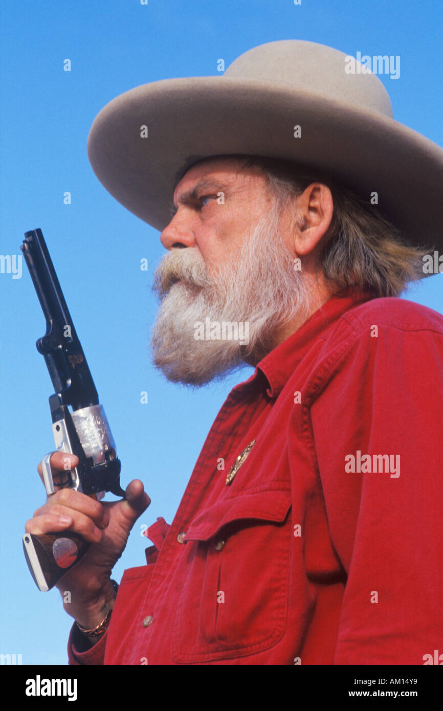 Old West gunslinger drawing guns during historical reenactment CA Stock Photo