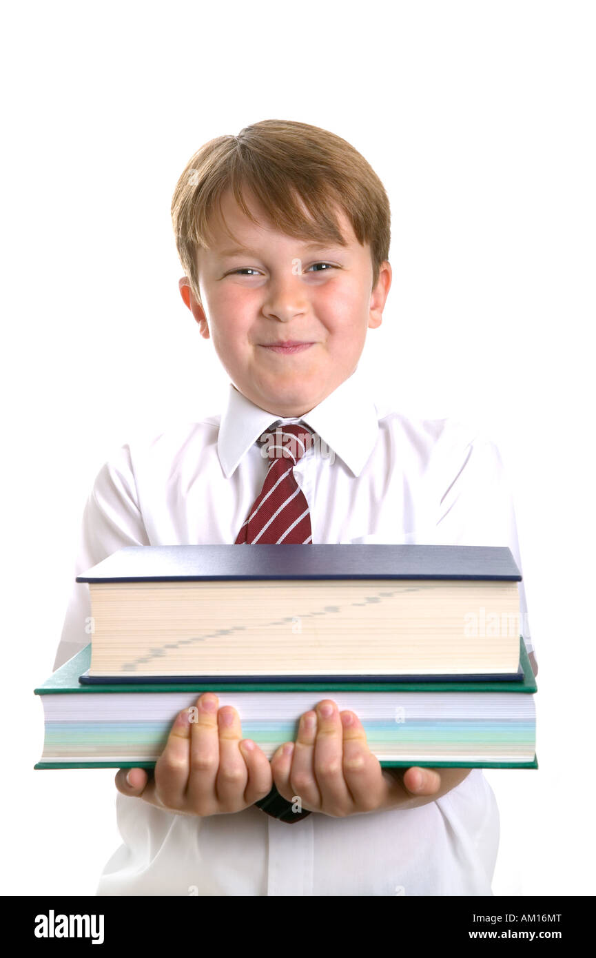High key shot of a school child in uniform holding some reference books Stock Photo