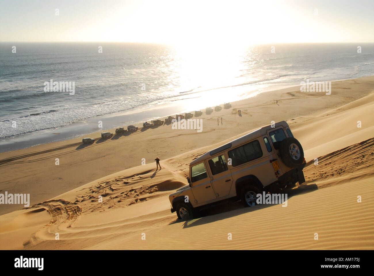 Jeep drives down a dune to the Atlantic Ocean, Fischersbrunn, Diamond Area, Namibia Stock Photo