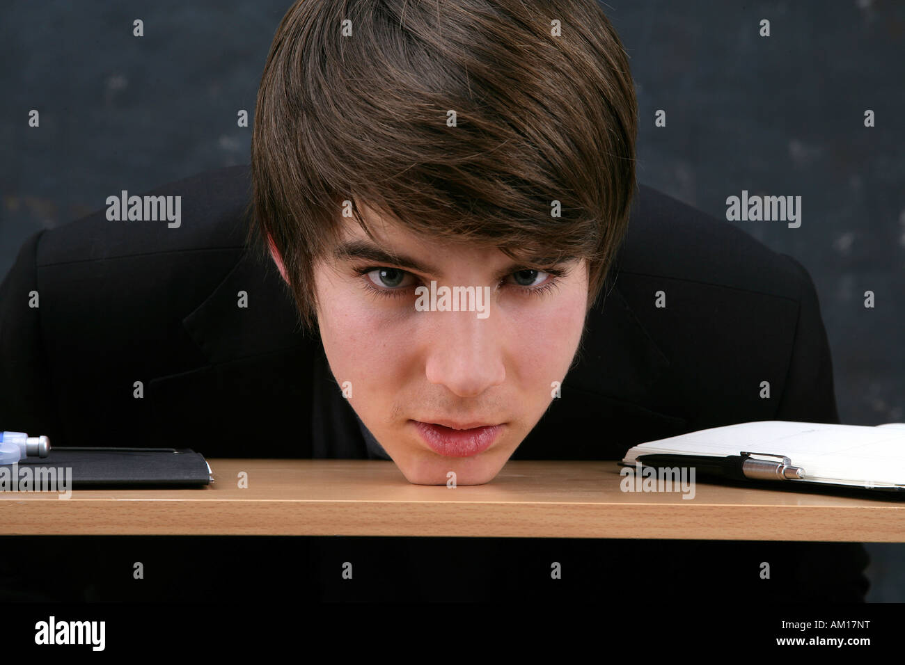 Young man resting the head on a desk Stock Photo