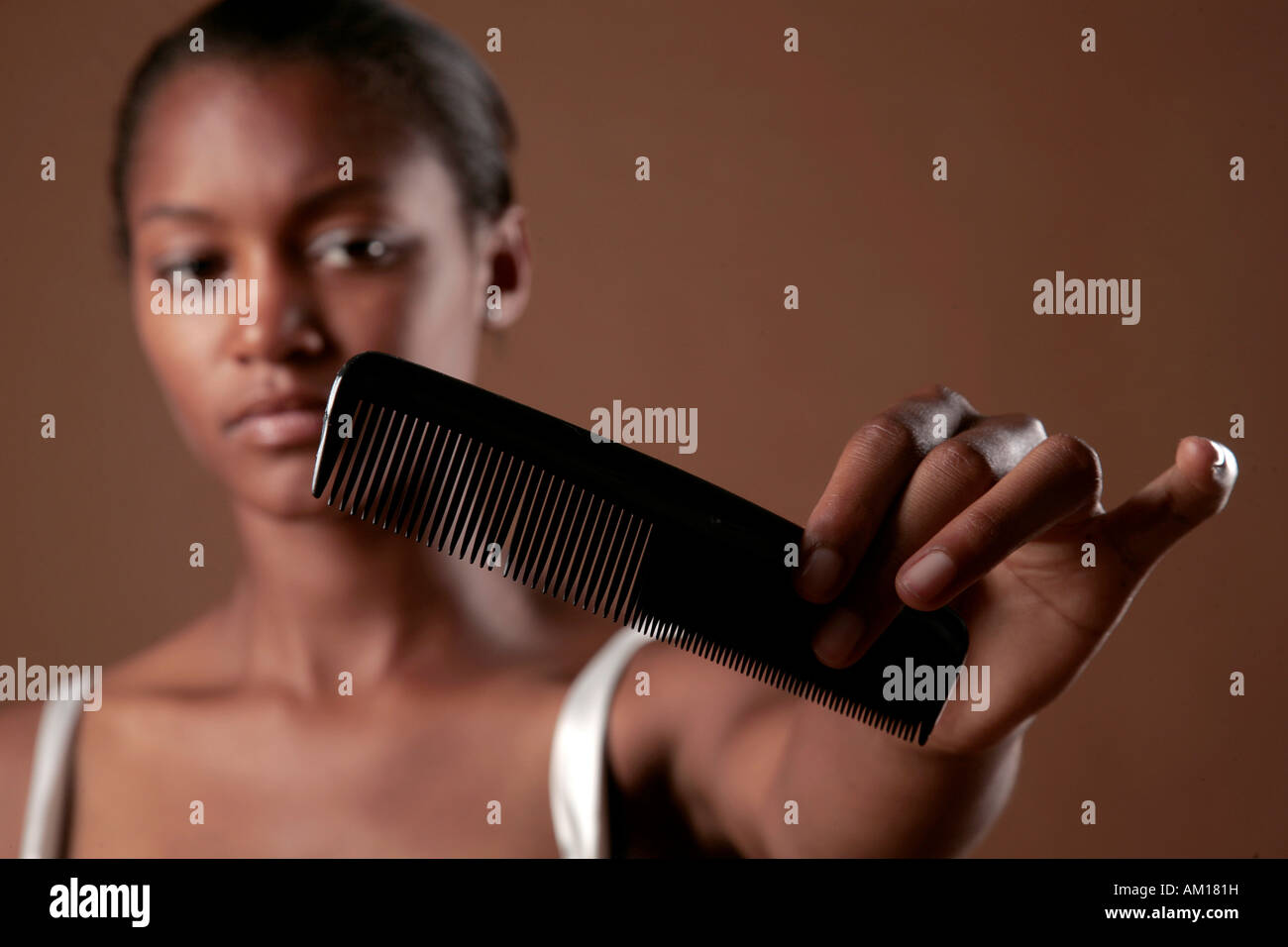Young dark-skinned woman with comb Stock Photo