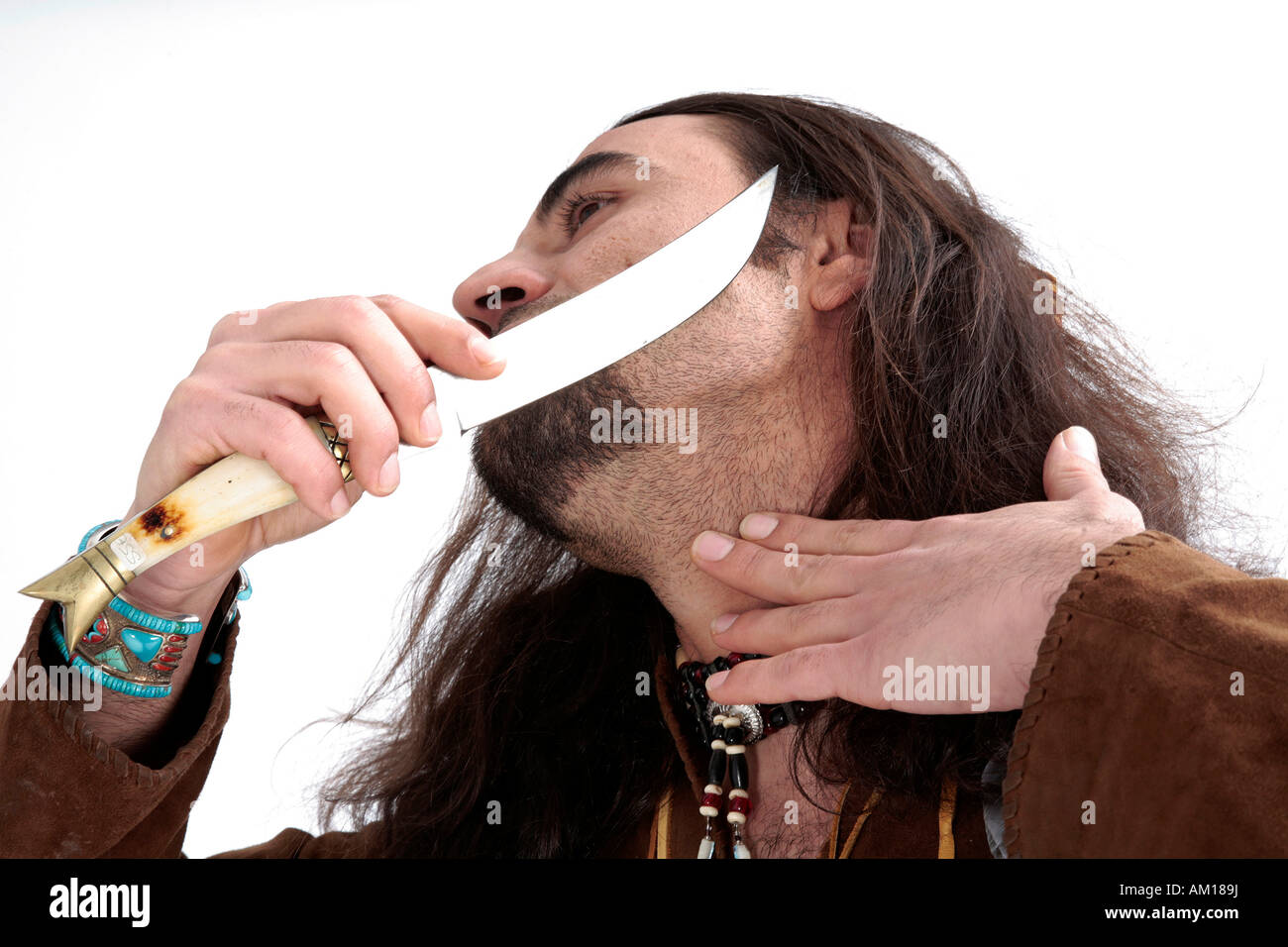 Man wearing indian clothing, shaving with a knife Stock Photo