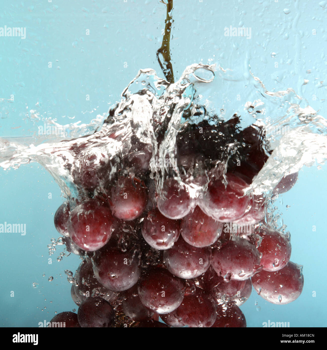 Bunch of grapes falling into water Stock Photo