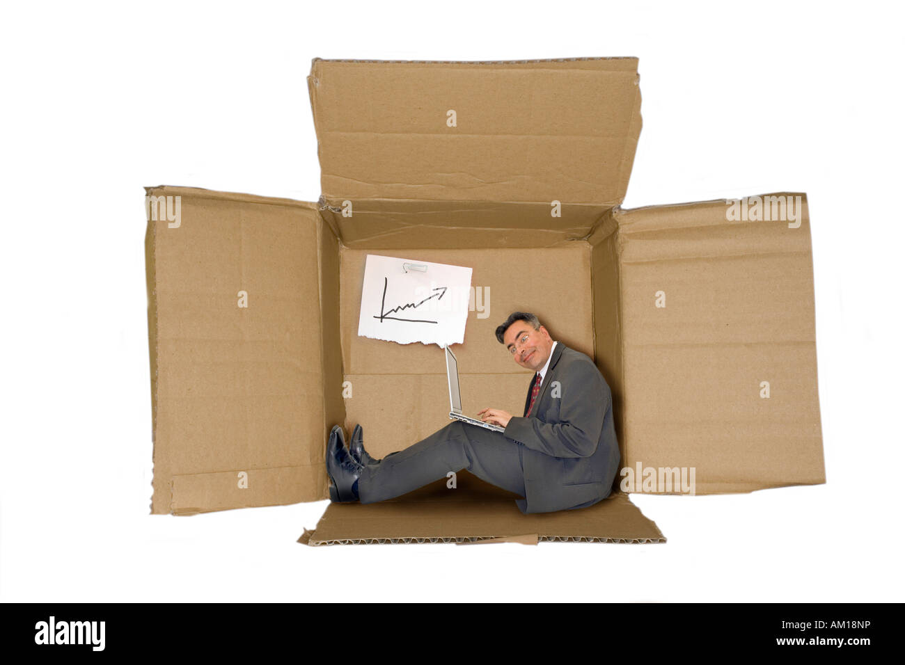 Businessman sitting his his new office made from paperboard Stock Photo
