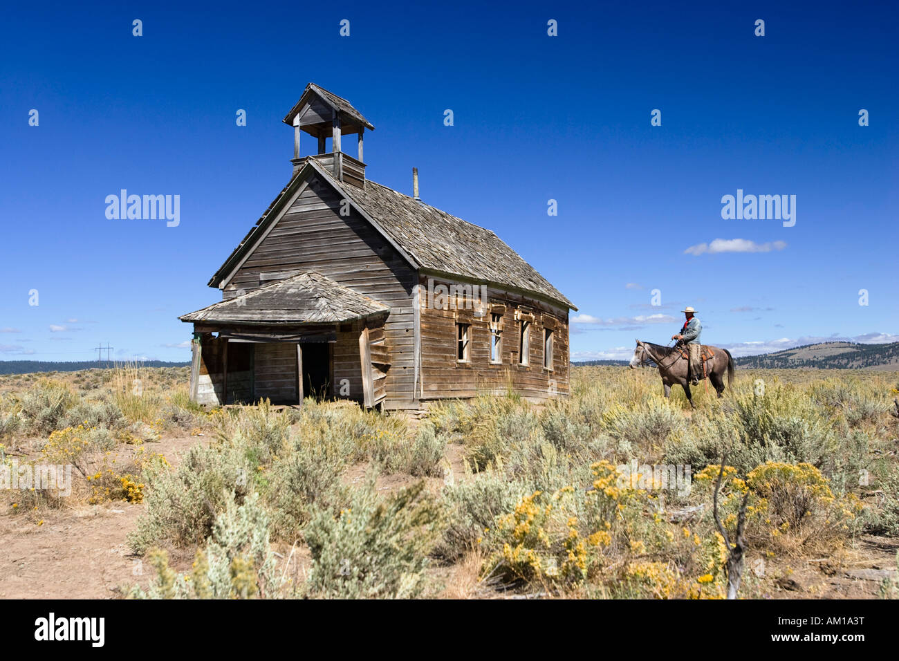 Cowboy with horse at old schoolhouse, wildwest, Oregon, USA Stock Photo