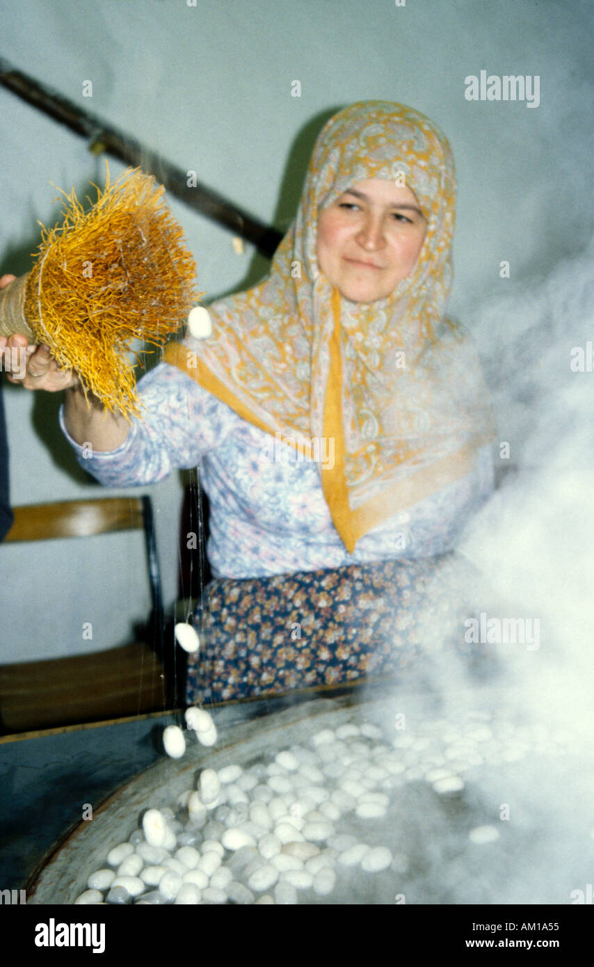 Silk worm worker working with the cocoons and fine threads in the silk making process Stock Photo