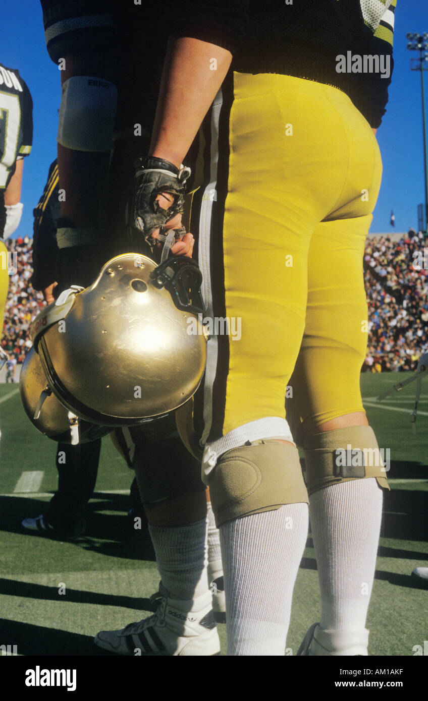 View of football player from behind and from waist down standing on field holding helmet West Point NY Stock Photo
