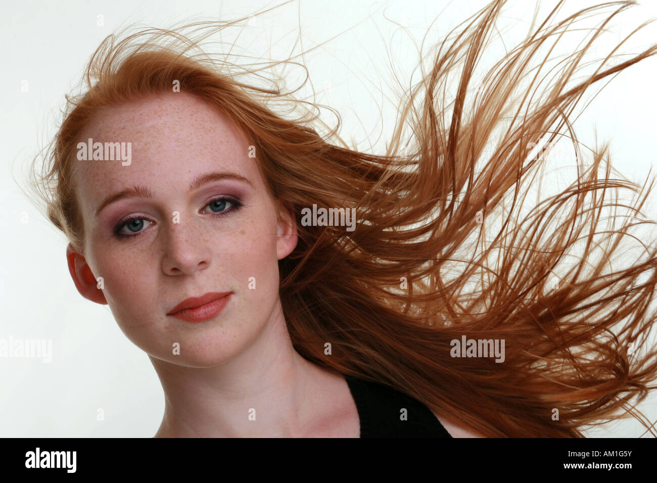 Portrait of a girl with moving red hair and freckles Stock Photo