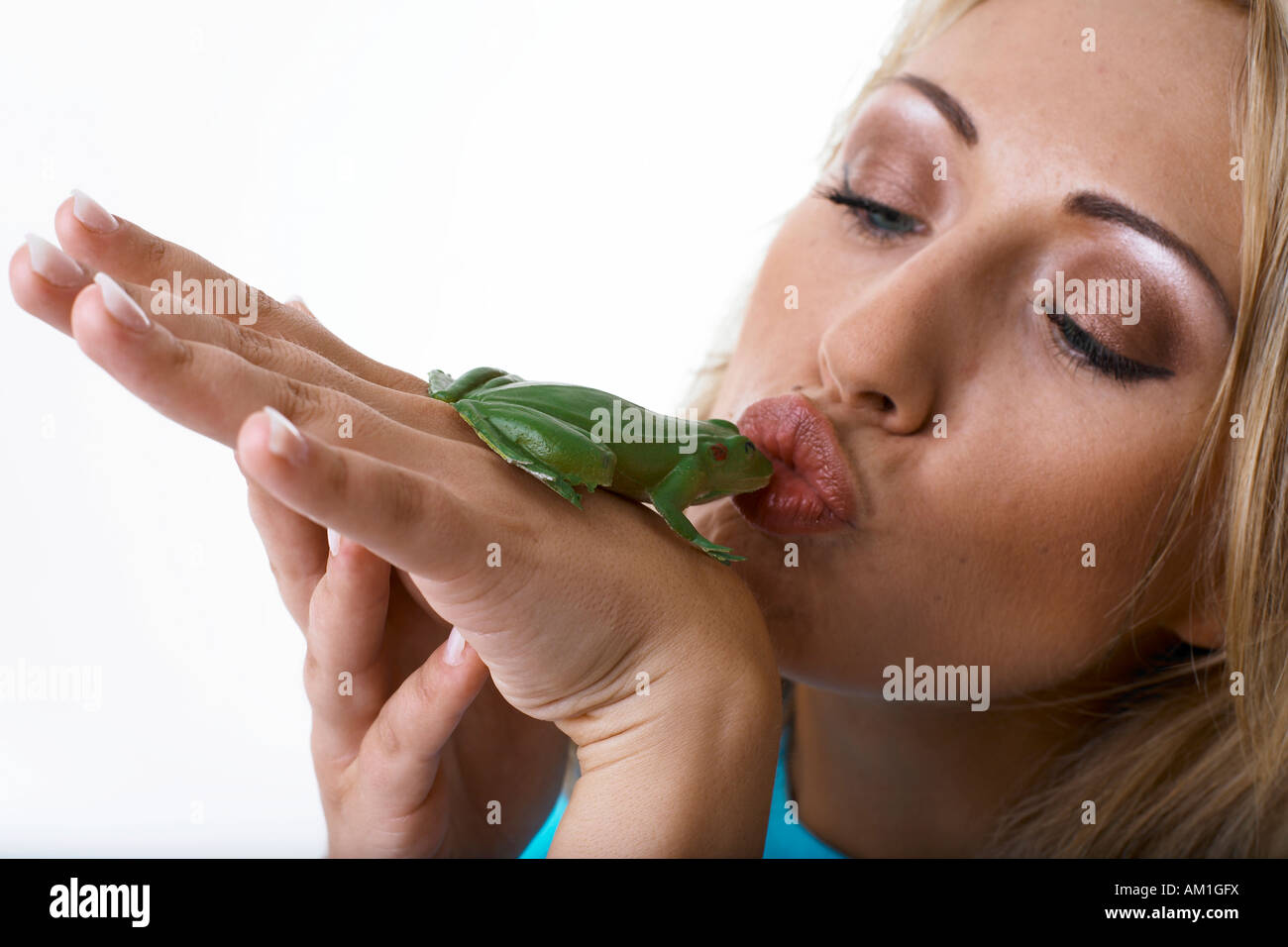 A young woman is kissing a frog Stock Photo