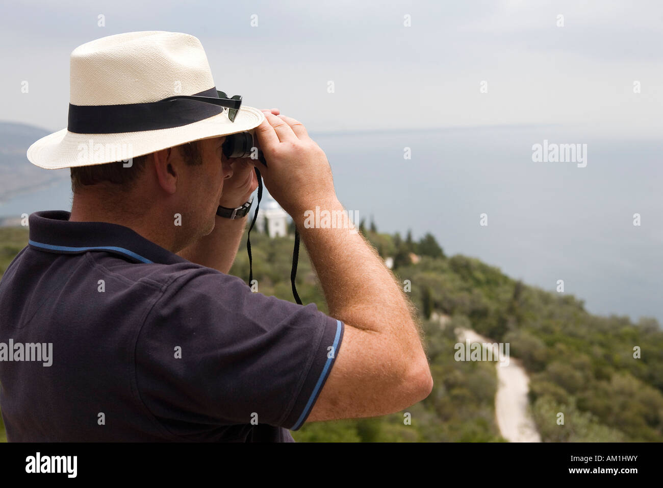A man looking through a binocular Stock Photo