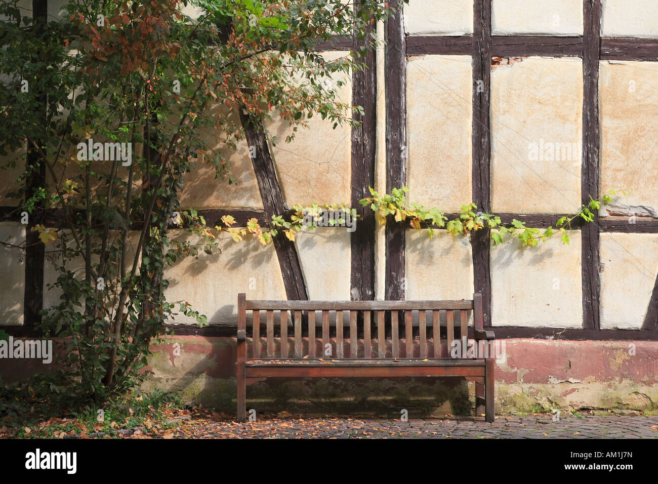 Wooden bench in front of a timbered house facade Stock Photo