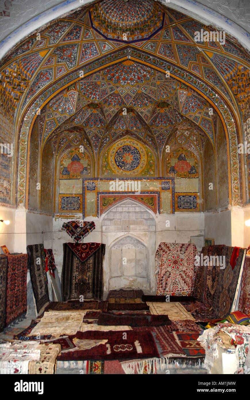Decorated arch with mihrab now shop selling suzani and carpets in Khanaka Nadir Divan-Begi Lyab-i Hauz Bukhara Uzbekistan Stock Photo
