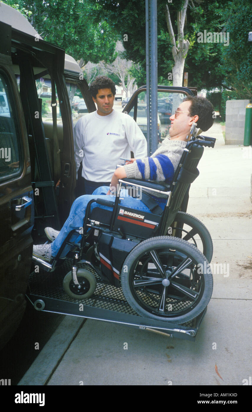 Wheelchair bound young man getting into specially equipped van Stock Photo