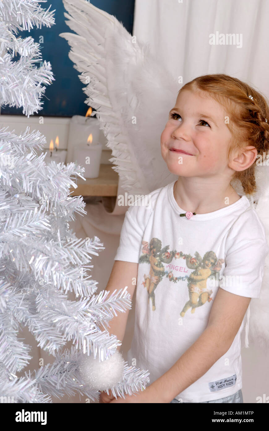 Child decorates a white christmas tree Stock Photo