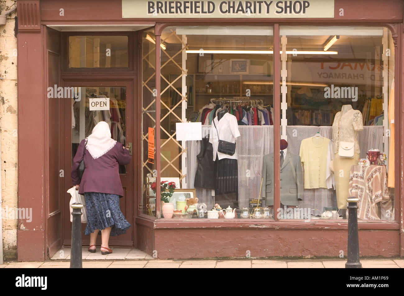 women entering a charity shop in Brierfield Lancashire Stock Photo