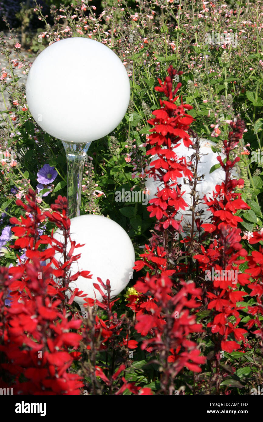 white round glass garden spheres and red sage flowers at Buga Munich Muenchen Bavaria Germany