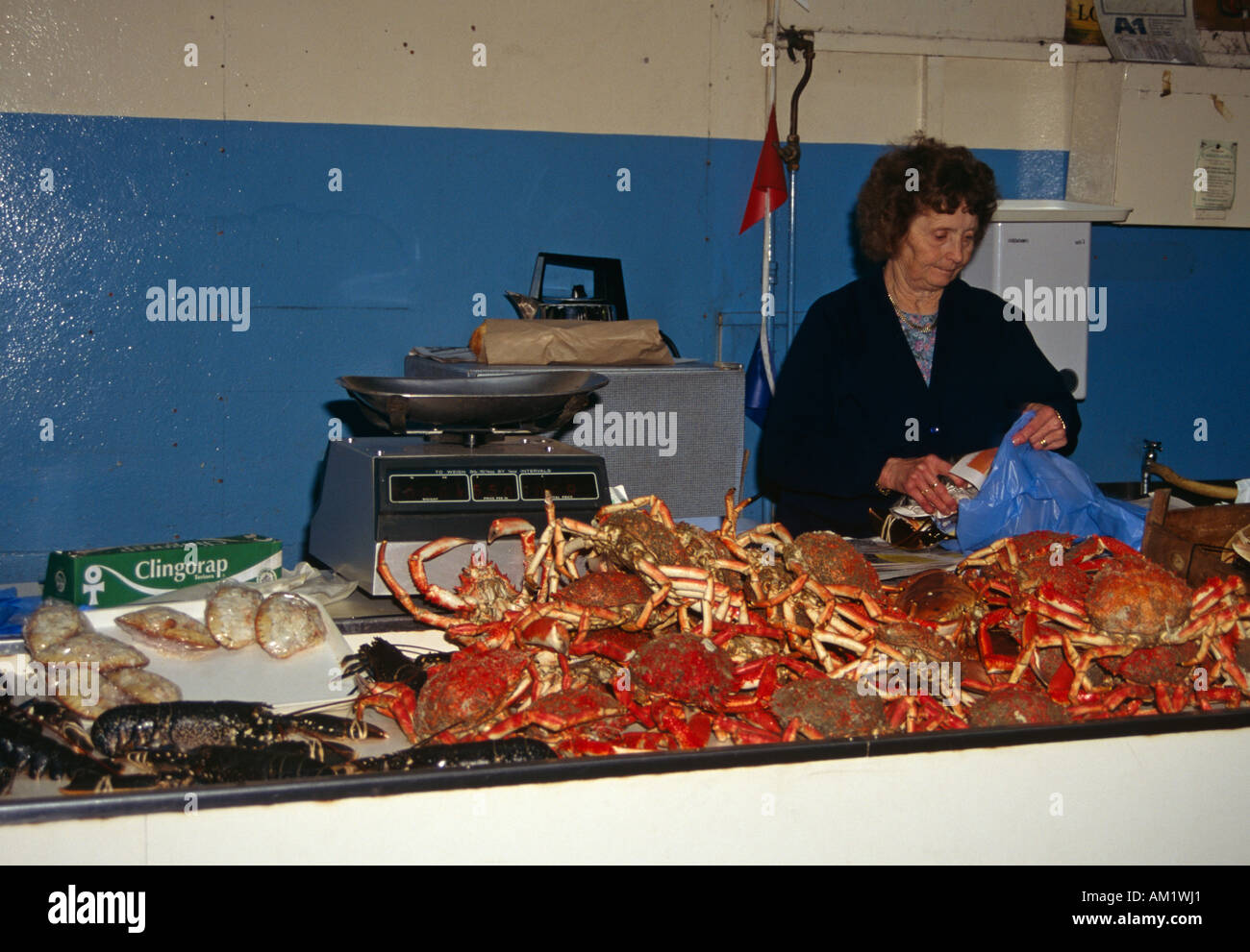 Lady fishmonger selling crabs and lobsters in the Fish Market, St Peter