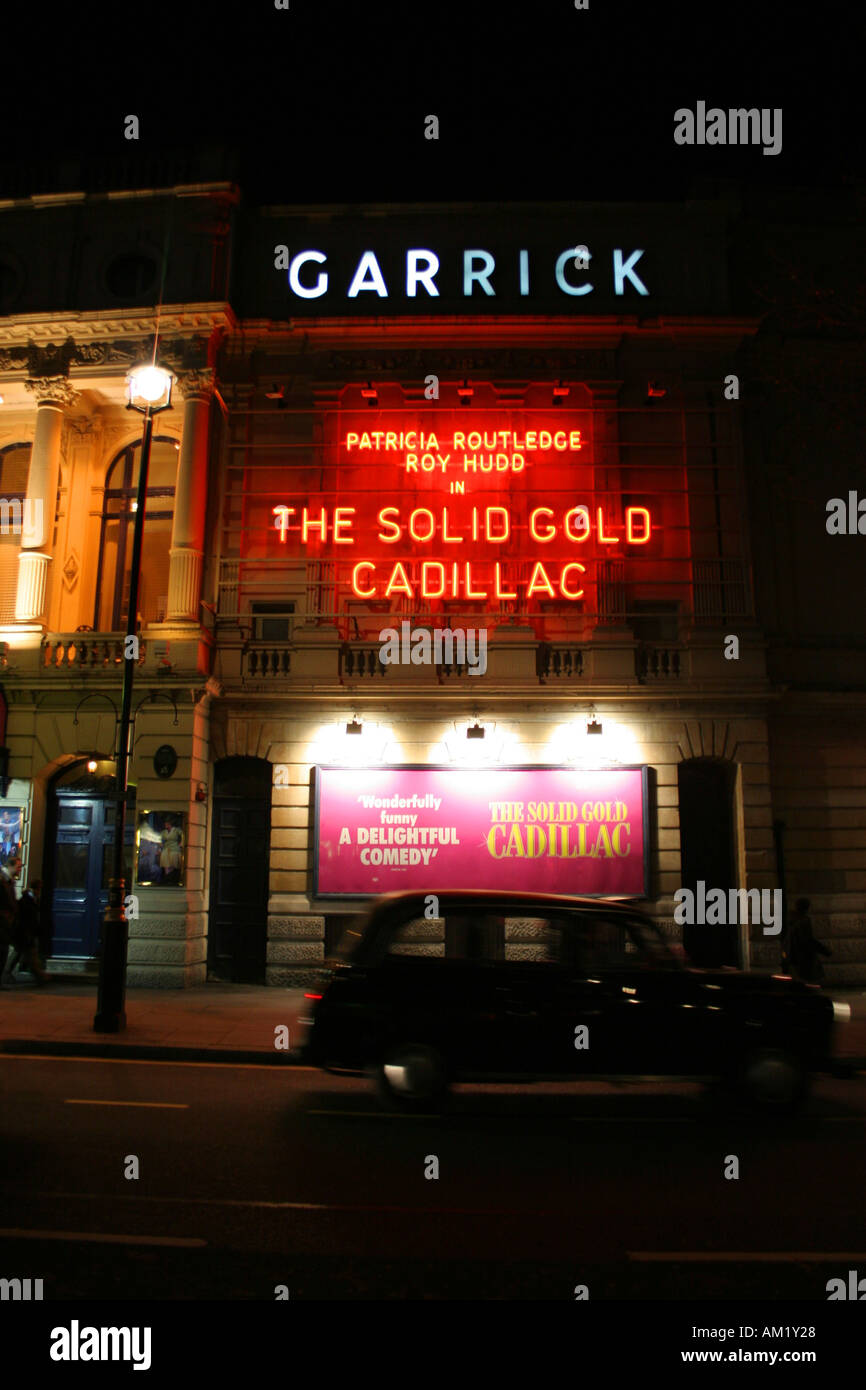 London's Garrick theatre at night with solid gold cadillac poster Stock Photo