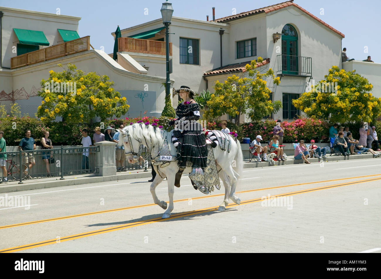 Woman with black Spanish dress riding horse during opening day parade down State Street Santa Barbara CA Old Spanish Days Stock Photo