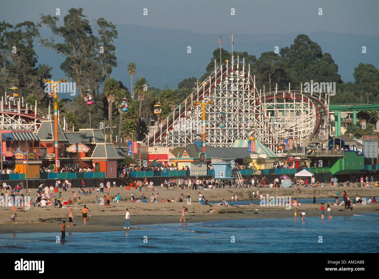Santa Cruz sand beach boardwalk amusement rides rollercoaster people ...