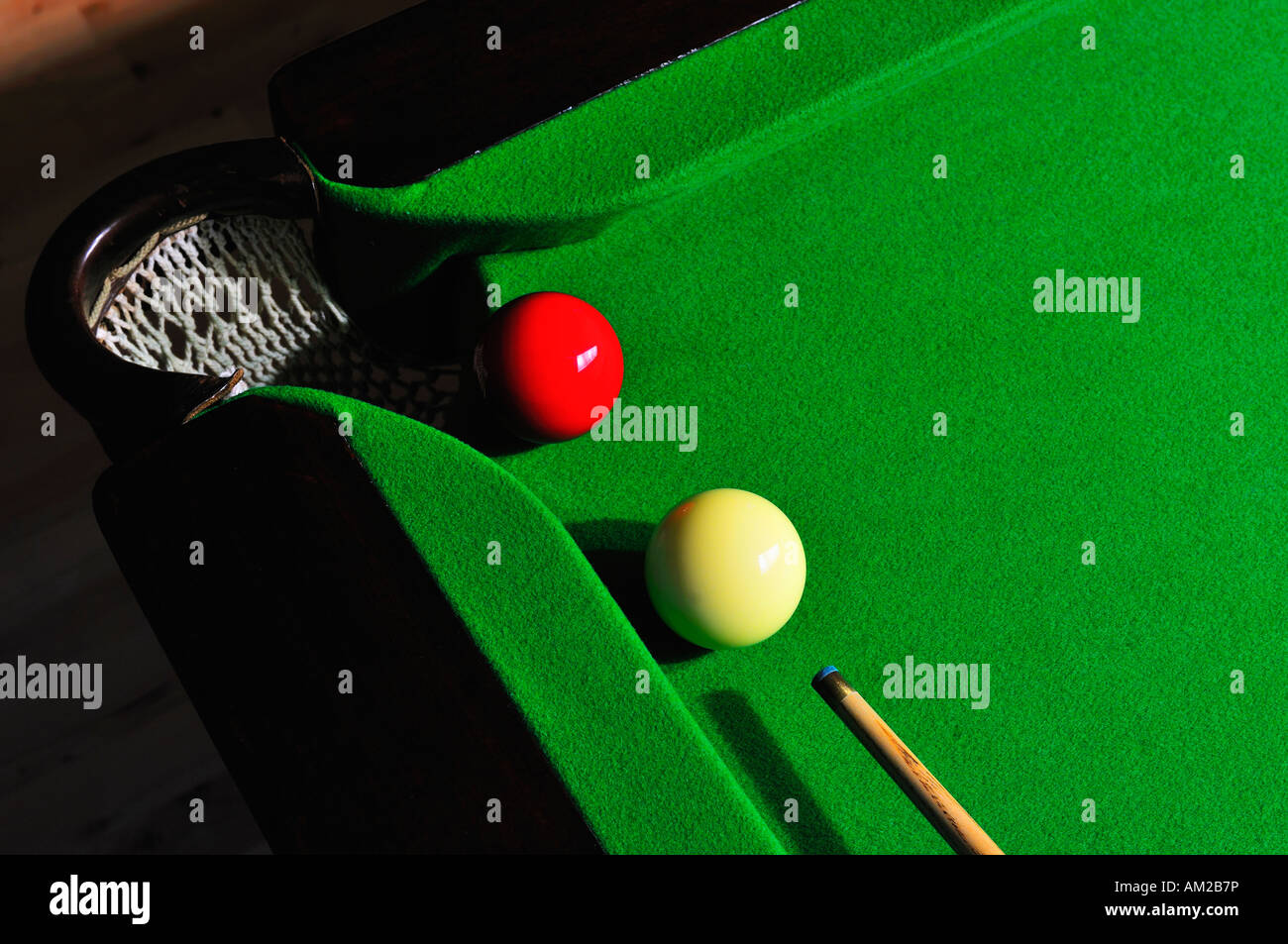 A game of billiards or snooker. The red ball is about to be potted