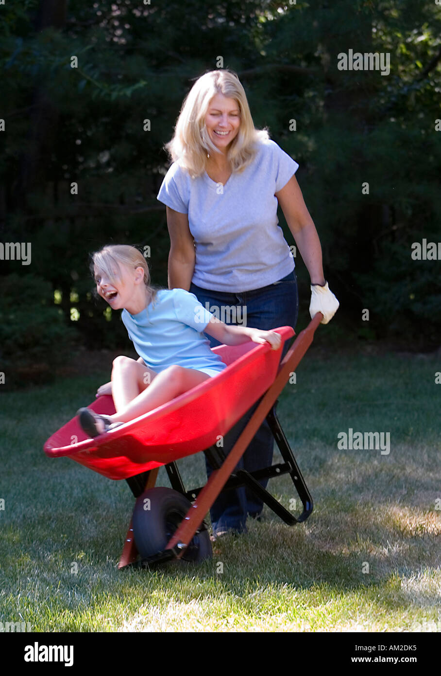 Mother carrying her daughter in a wheelbarrow Stock Photo - Alamy
