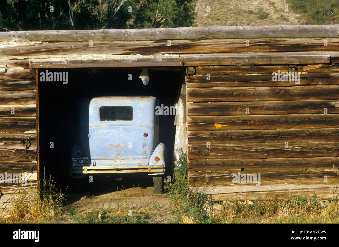An old car in a log cabin garage in Snowmass Colorado Stock Photo