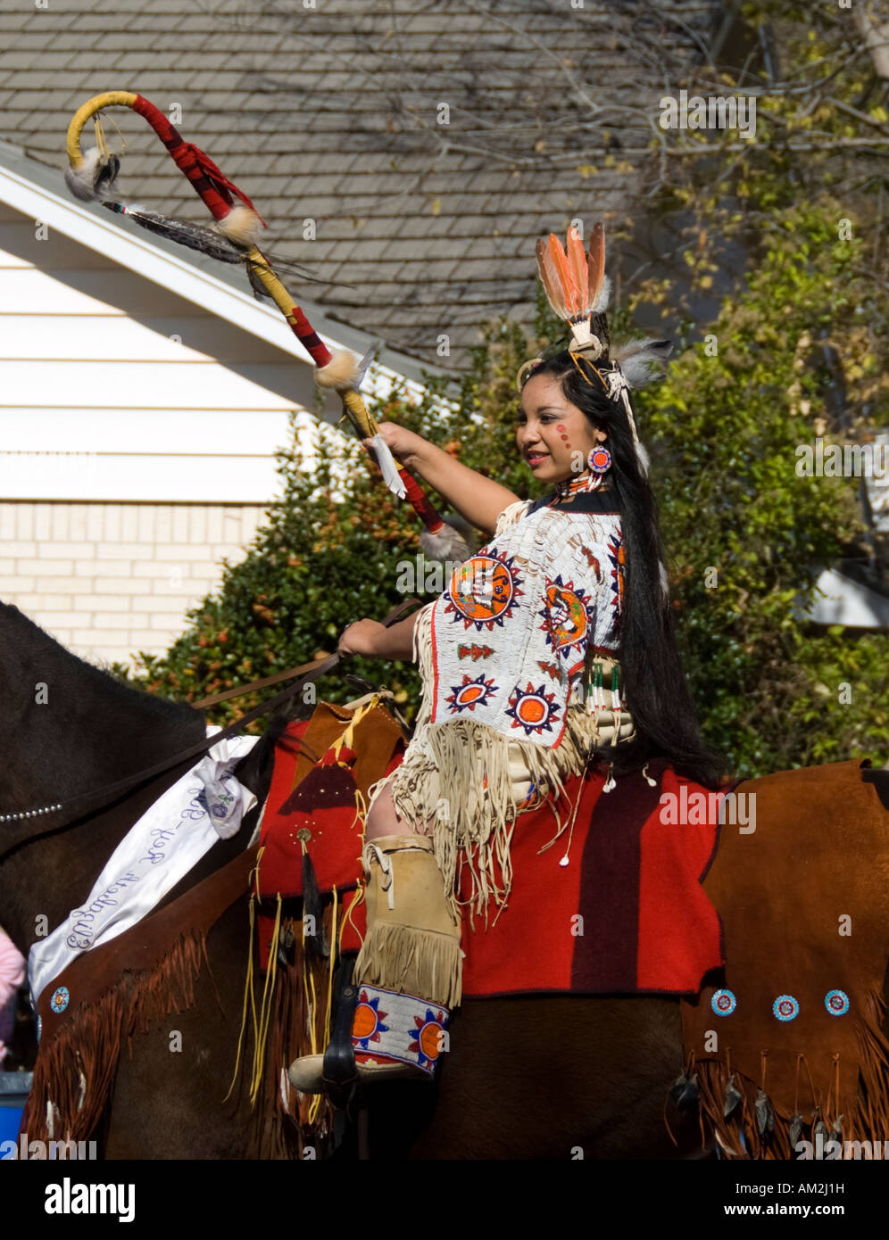 An American Indian girl rides her horse in a centennial parade in