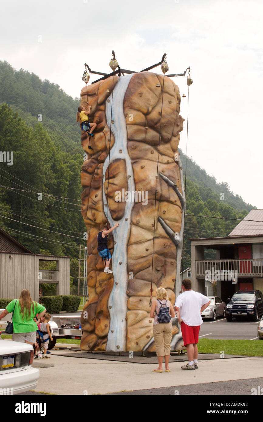 Parents watch as young children climb artificial rock climbing wall in Cherokee North Carolina USA Stock Photo