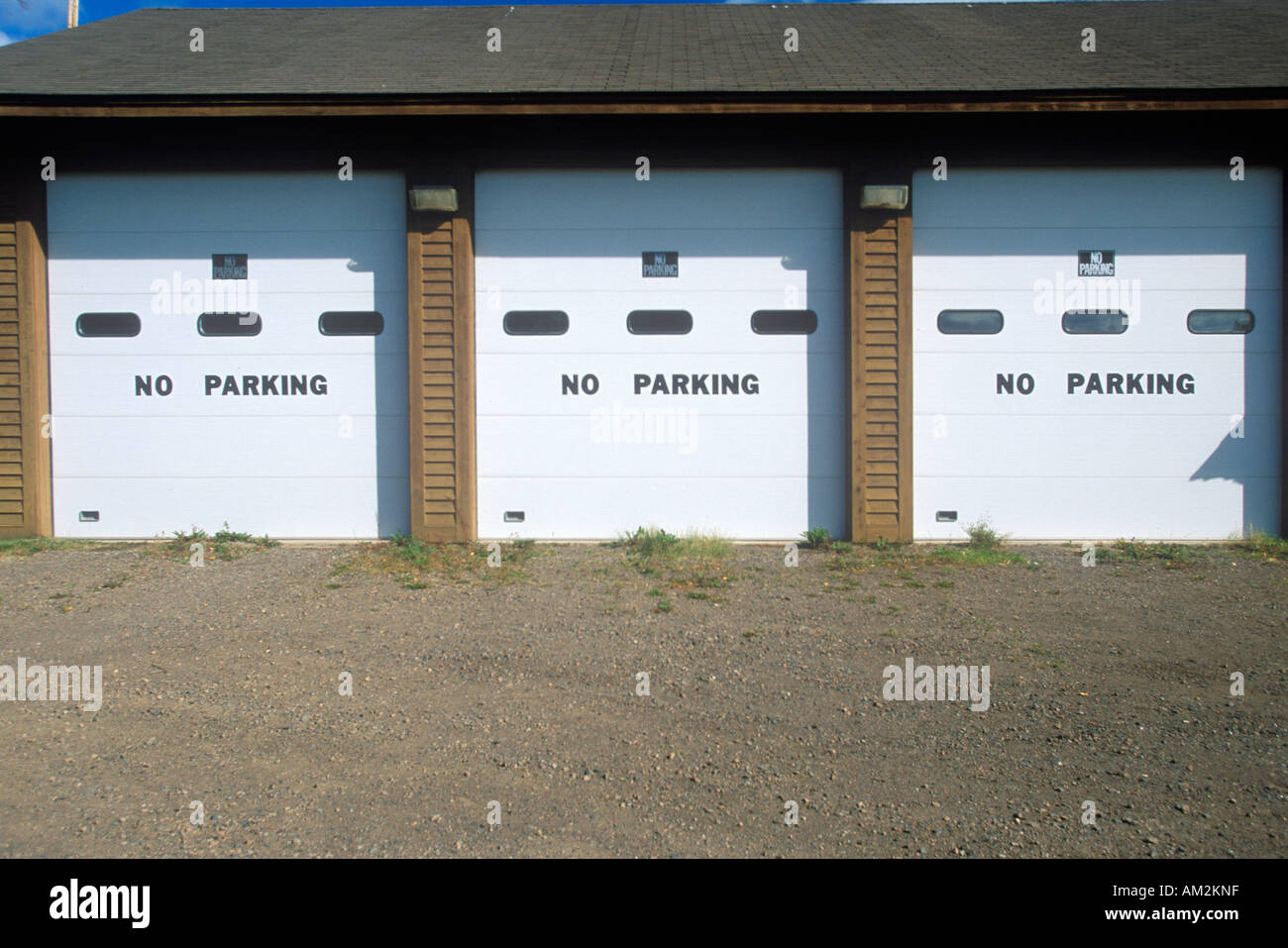 No Parking signs on a garage door Stock Photo - Alamy