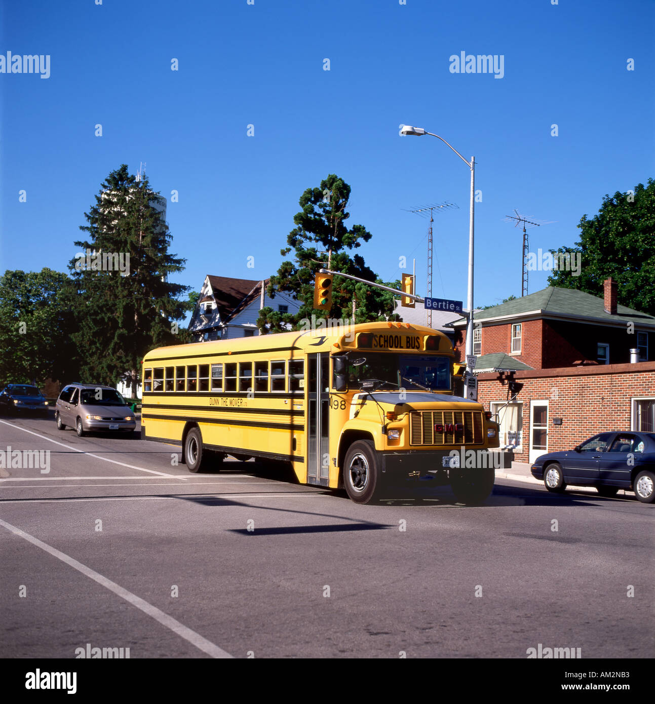 Front view of a yellow Canadian school bus crossing an intersection at Bertie Street traffic lights in Fort Erie Ontario Canada  KATHY DEWITT Stock Photo