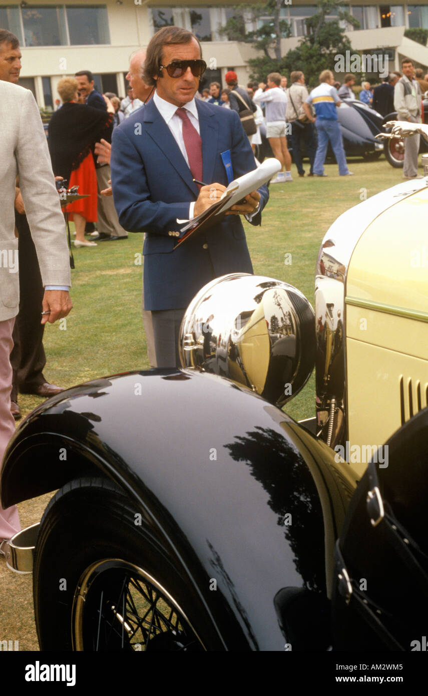 The Scottish race car driver Jackie Stewart examines a vintage Bugatti