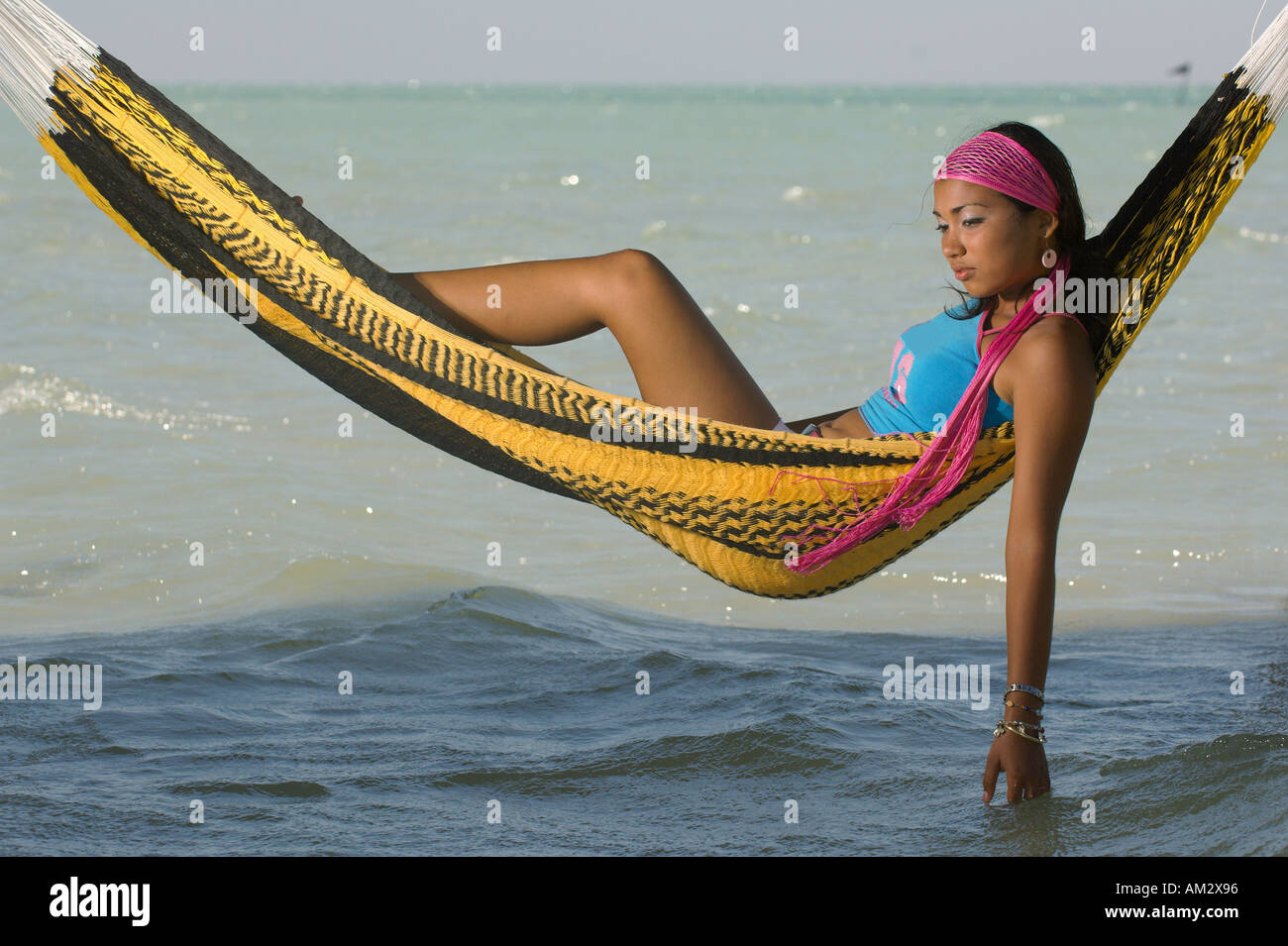 Mexican teen girl relaxes on the beach while on vacation at San Felipe Yucatan Mexico Stock Photo