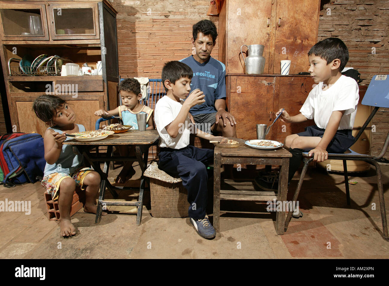 Guarani family eating, single father, in the poor area of Chacarita, Asuncion, Paraguay, South America Stock Photo