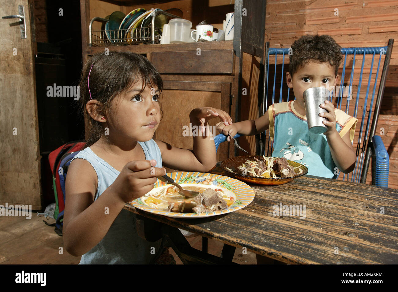 Guarani children eating, in the poor area of Chacarita, Asuncion, Paraguay, South America Stock Photo