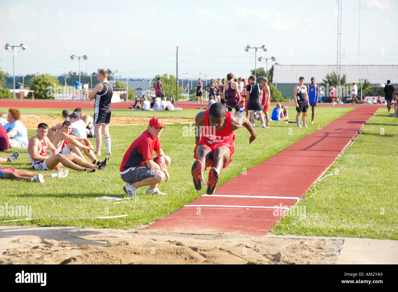Afro American teenage boy in the long jump at a track and field