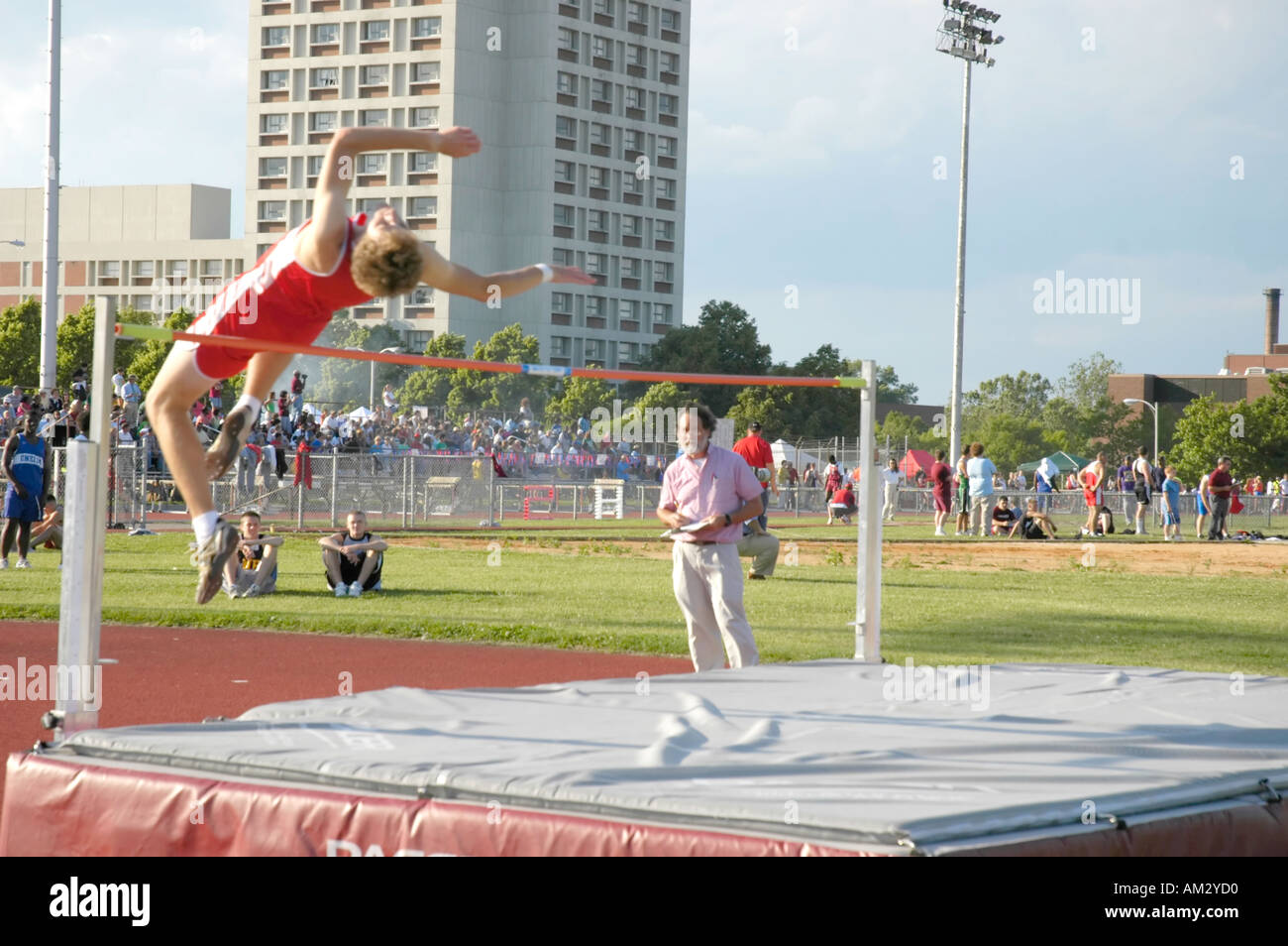 Teenage boy high jumper clearing the bar at a high school track and