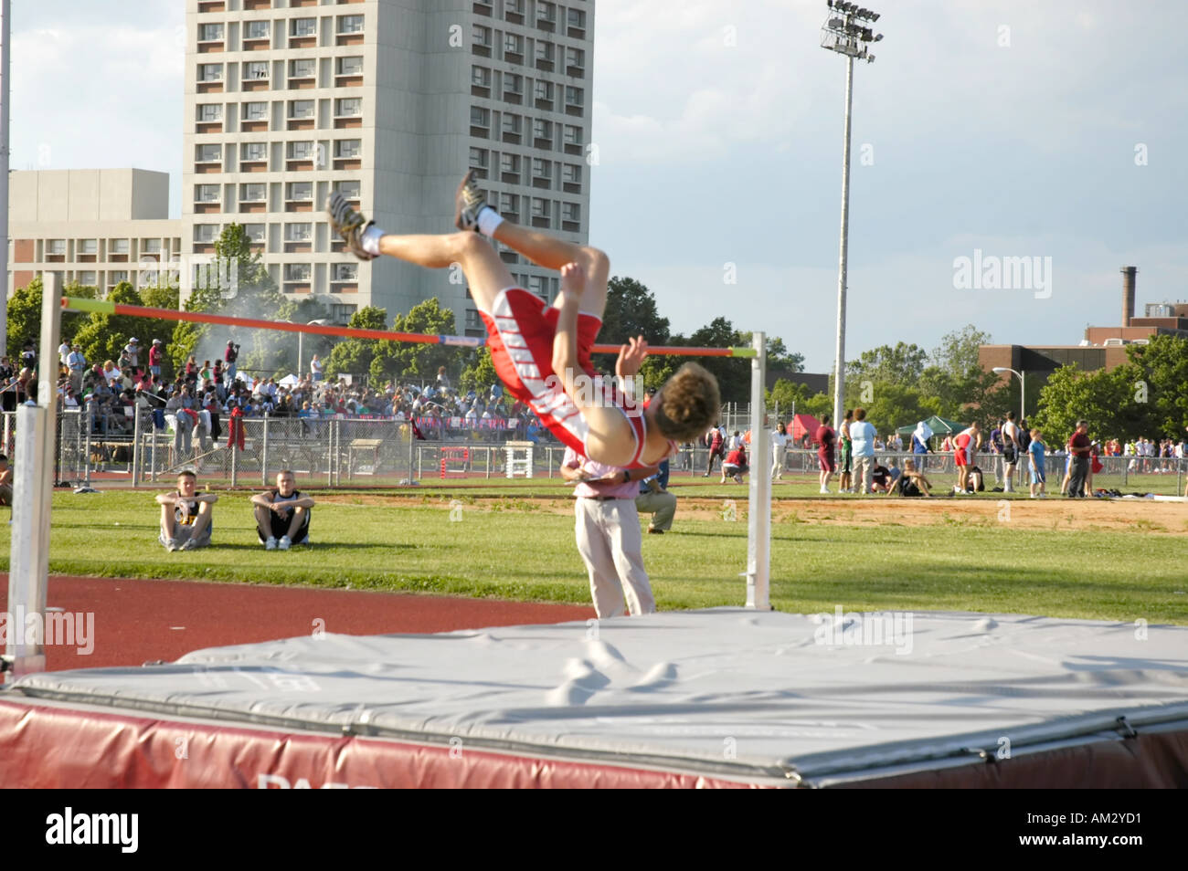 Teenage boy high jumper clearing the bar at a high school track and