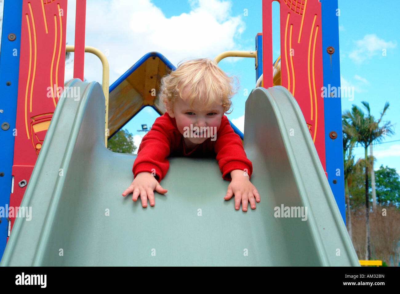 boy toddler getting ready to go down a slide Stock Photo Alamy