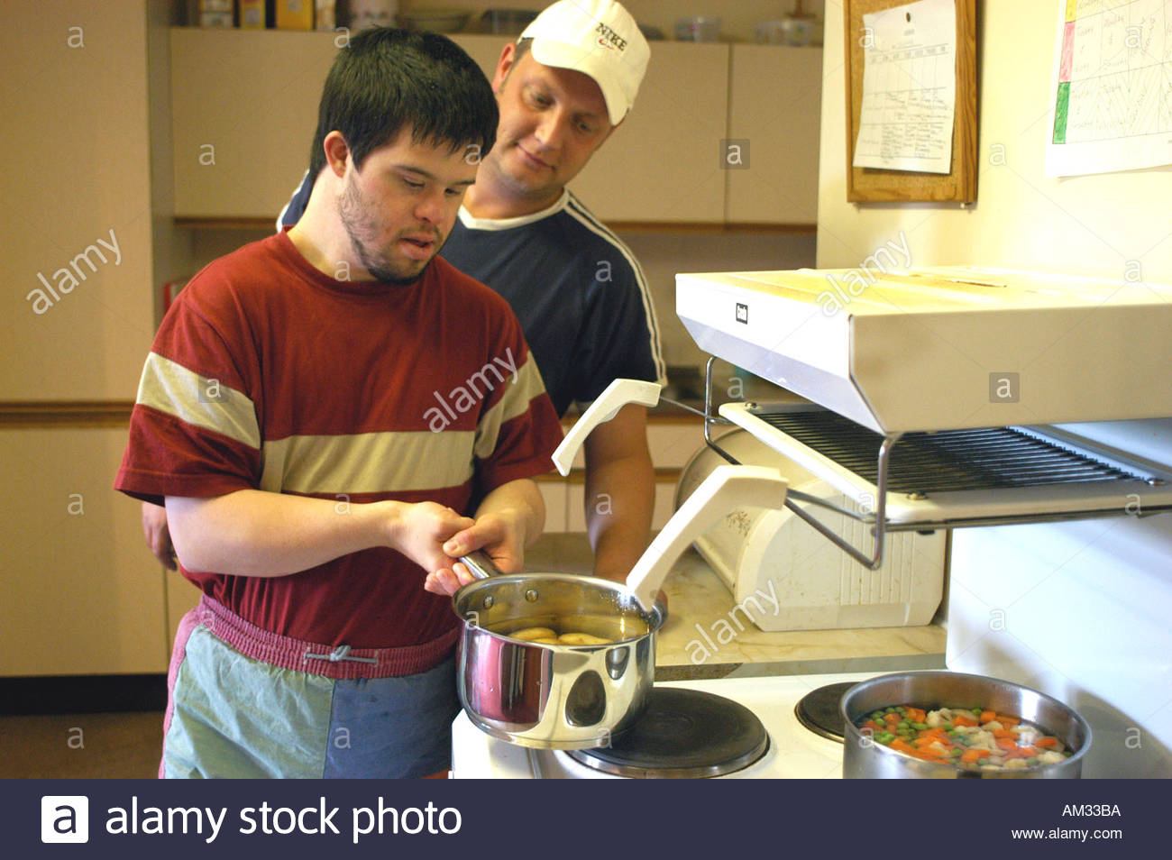 Man with learning disability cooks his own meal in a sheltered Stock