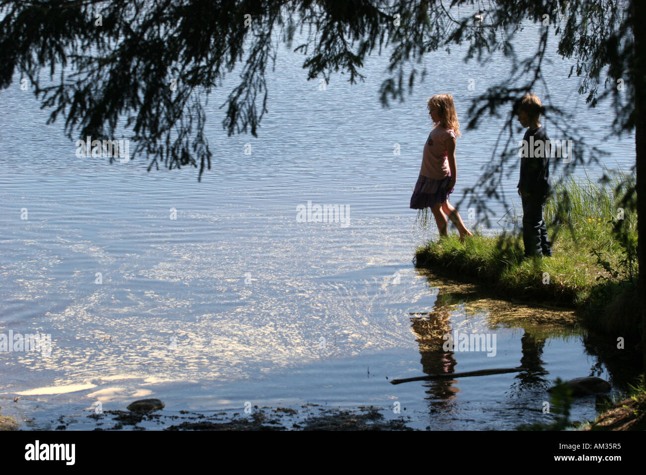 2 children silhouette lake forest river Stock Photo