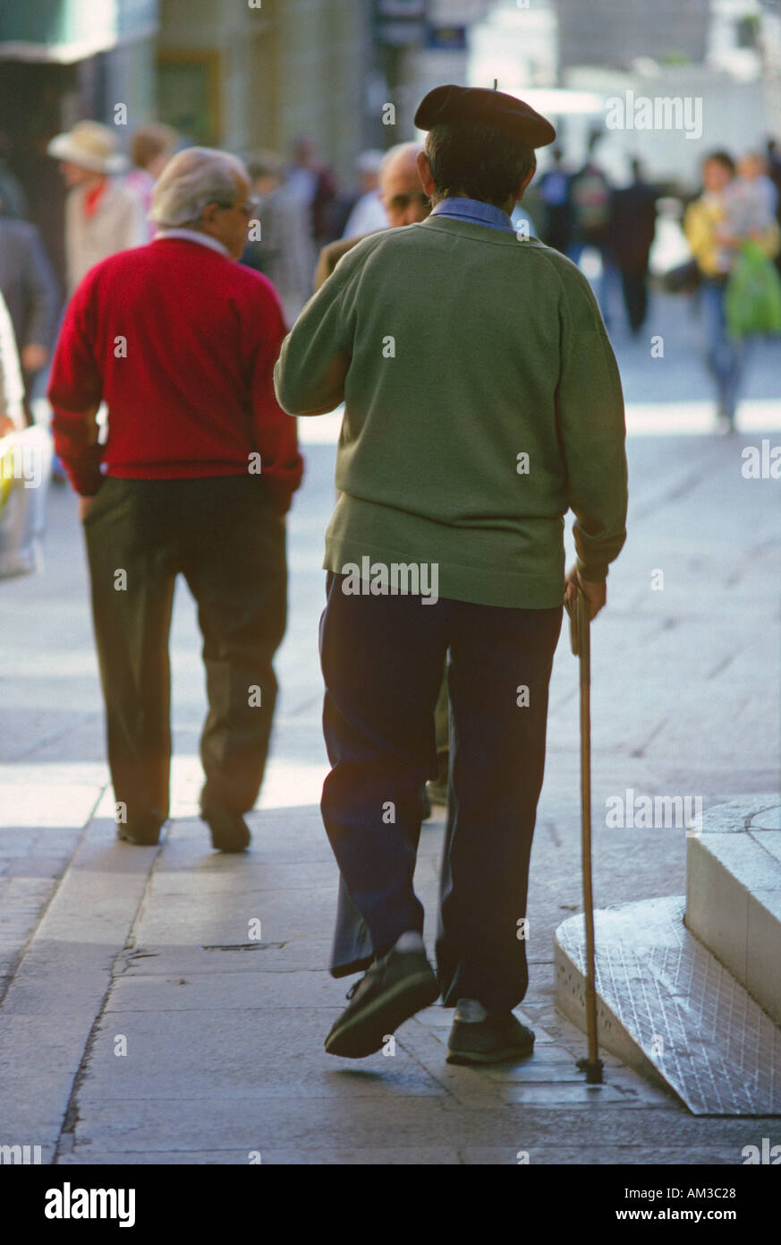 Elderly men walking along a busy street in Segovia Castil…