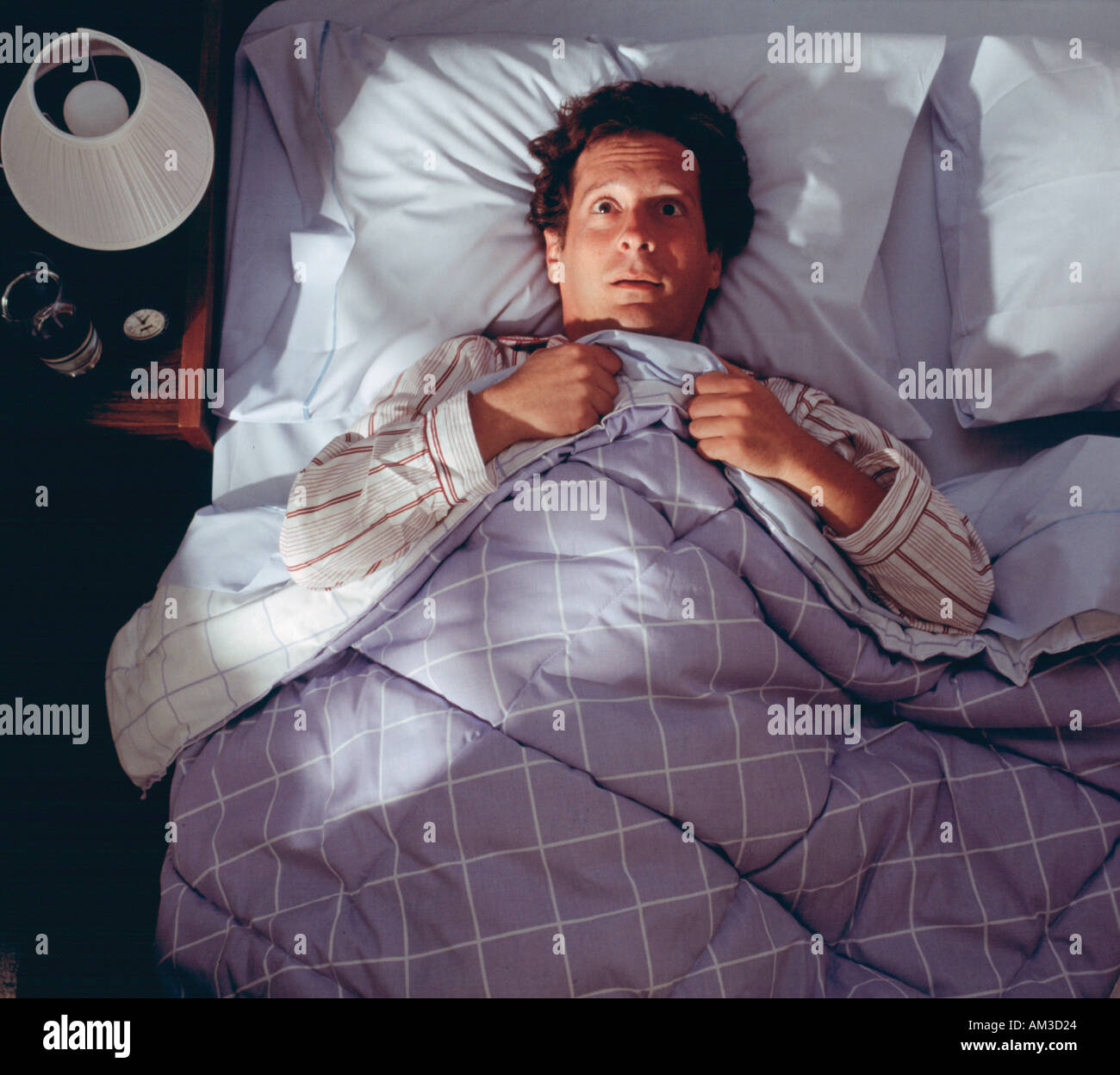 man awake in bed not sleeping, worried insomniac Stock Photo