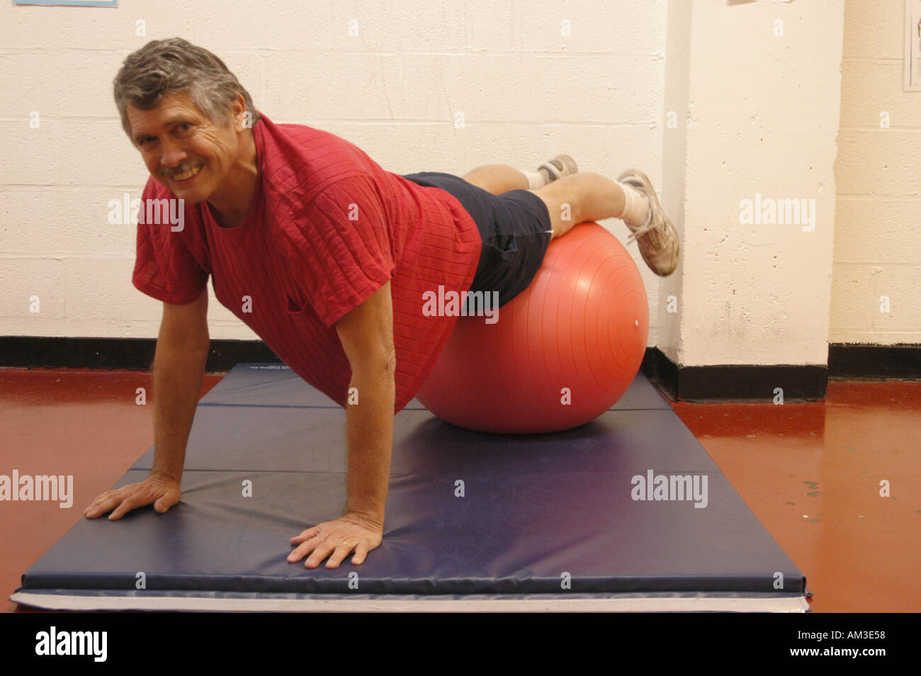 Older man doing push ups with exercise ball Stock Photo