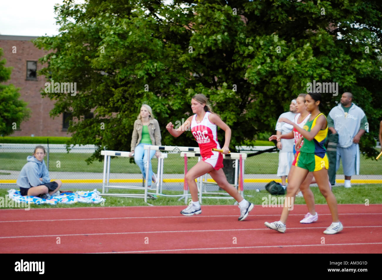 Teenage girl relay race runners at a high school track and field